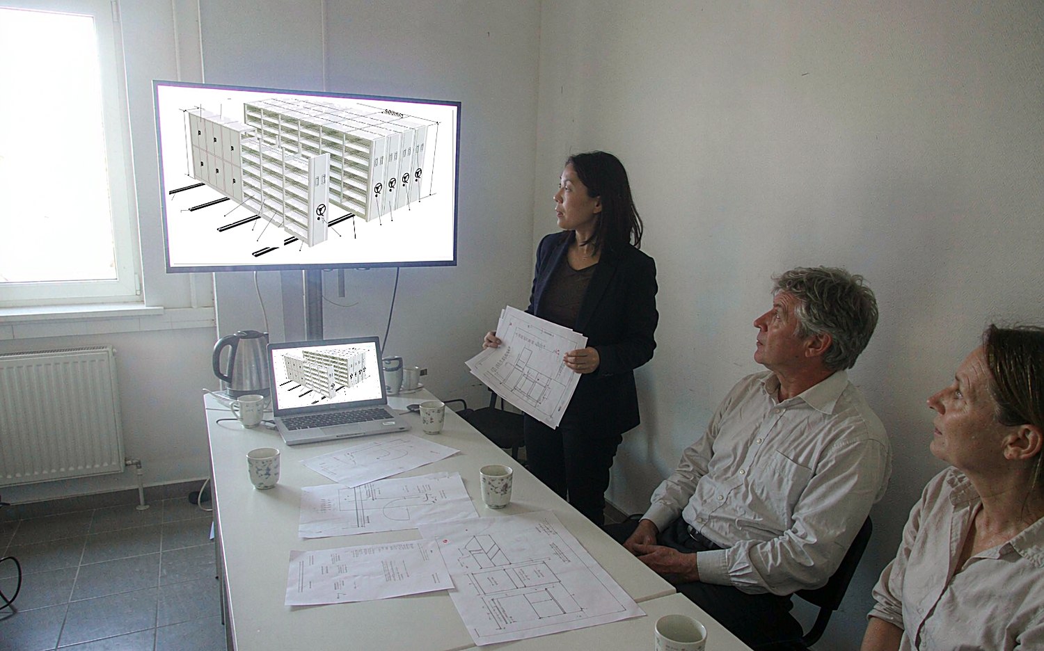 Shelving design drawings reviewed with overseas clients in the meeting room