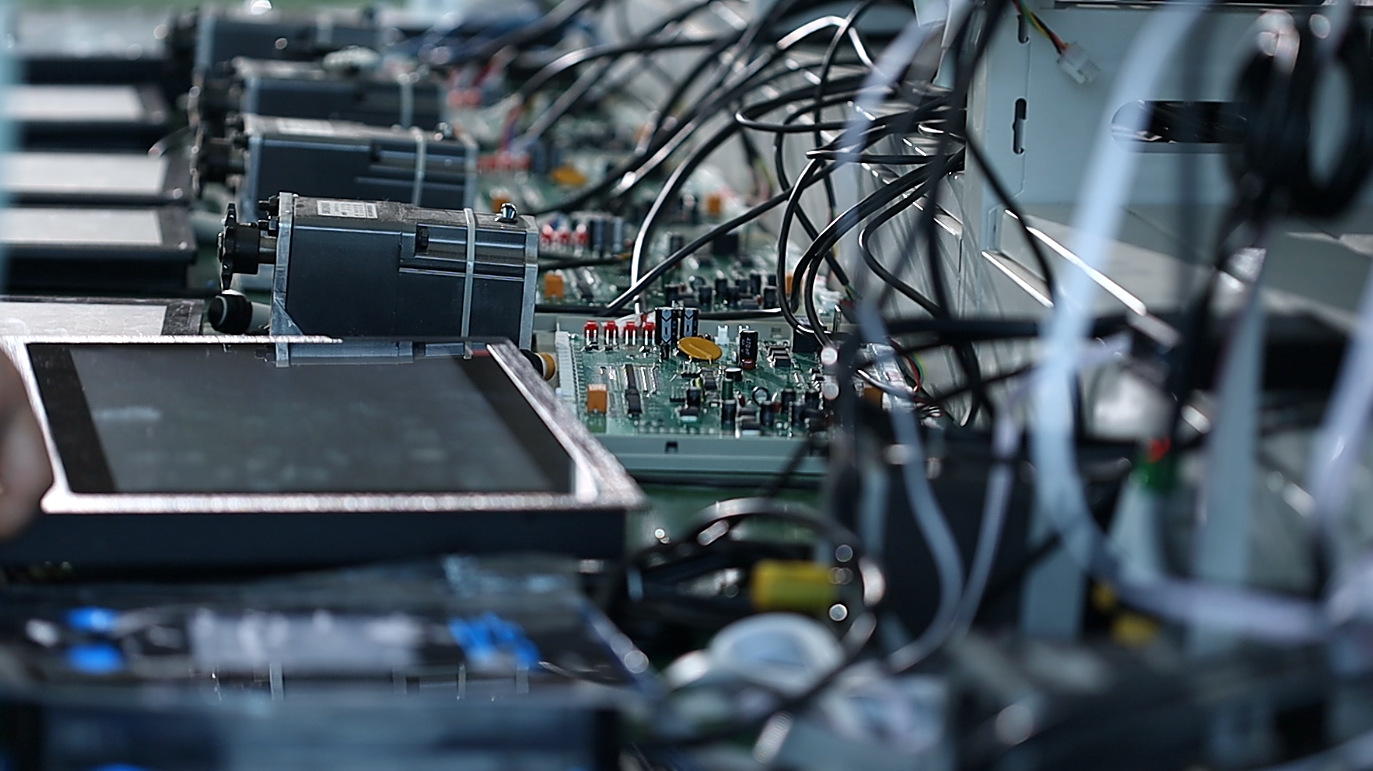 Shengmei control system hardware: motor drive boards, wiring harnesses and touch terminals on the R&D bench